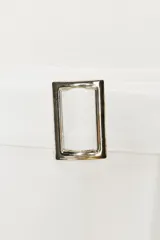 Falda blanca de corte evasé, largo a la rodilla, con cinturón ajustable con hebilla metálica.
