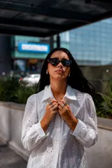 Camisa color beige con bordado inglés, de corte recto, manga larga abullonada con puño y cuello camisero.