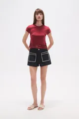 Remera cropped ajustada al cuerpo de algodón, color blanco, con cuello redondo y un borde inferior de encaje calado con diseño floral.