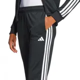 Conjunto deportivo Adidas Essentials de mujer, color negro con tres bandas blancas en mangas y piernas. Incluye campera con cierre y pantalón recto.