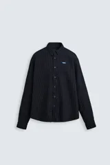 Camisa negra con finas rayas verticales blancas, de corte holgado, manga larga y cuello abotonado.