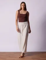 Pantalón largo color beige a rayas verticales, con pretina ancha elastizada en punto smock y pierna ancha.