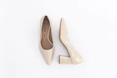 Zapato de tacón color beige, de cuero charol, con punta fina y taco cuadrado.