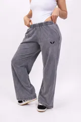 Pantalón deportivo gris con efecto lavado, corte ancho, cintura elástica y logo bordado en negro.