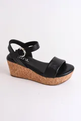 Sandalia plateada con plataforma de corcho, diseño cruzado y tira con hebilla al tobillo.