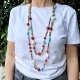 Collar largo de cadena de bronce con cuentas de coral, turquesa y nácar.