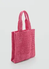 Bolso shopper grande color fucsia, tejido en fibra natural con diseño calado. Tiene doble asa corta de mano y es de estilo shopper.