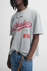 Camiseta gris con cuello redondo y manga corta. Presenta estampados, bordados y parches frontales combinados a contraste. Tiene un efecto lavado.