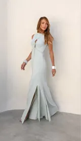 Vestido largo celeste con corte a la cintura, escote redondo con abertura circular y cadena metálica decorativa.