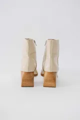 Botas cortas de cuero negro con cierre lateral y taco de madera.