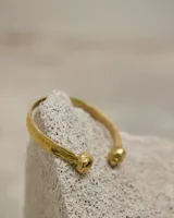 Brazalete rígido abierto de bronce con forma de herradura.