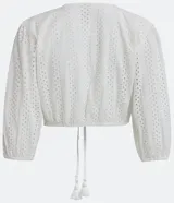 Blusa cropped blanca de laise texturizado con mangas 3/4 ajustadas y lazo en el bajo.