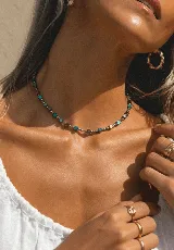 Collar corto de cuentas de cristal cuadradas en tonos turquesa, marrón y plateado.