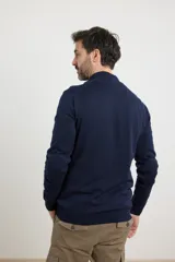 Cardigan azul de tejido de punto con cierre frontal y cuello alto.