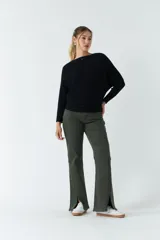 Sweater verde de punto liviano con textura acanalada y diseño de hombros caídos.