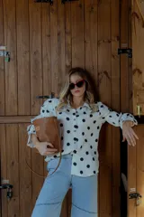 Cartera tipo canasto color marrón, con forma de cubo y diseño tejido. Incluye una bolsa interior de tela color chocolate con cierre.