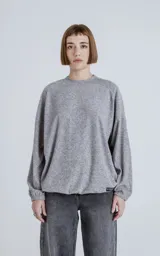 Sweater gris de corte holgado, cuello redondo y puños ajustados.