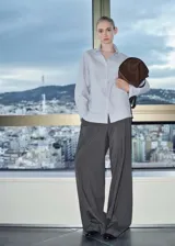 Camisa celeste y blanca a rayas verticales, de corte recto y mangas largas con puños abotonados.