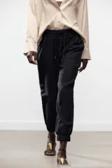 Pantalón jogger marrón de tiro alto con cintura elástica ajustable con cordones, bolsillos delanteros y puños elásticos en los tobillos.