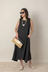 Vestido midi negro de corte suelto, sin mangas y con bolsillos laterales.