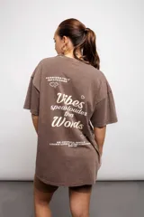 Remera marrón de corte holgado con estampado frontal de texto.