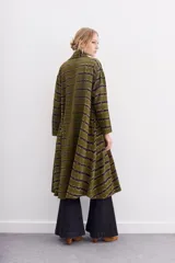 Kimono largo verde oliva con estampado batik en tonos morados. Tiene mangas largas, bolsillos laterales y se ata a la cintura con un cinturón blanco y negro.