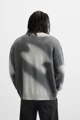 Jersey de punto gris con efecto tie-dye blanco, de corte relaxed fit, cuello redondo y mangas largas.