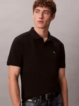 Chomba negra de piqué de algodón, corte clásico, cuello tradicional y tapeta de botones. Logo de Calvin Klein bordado en el pecho.