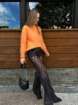 Pantalón de encaje negro con corte acampanado.