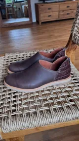 Zapato bajo marrón de cuero, con detalle de cuero texturizado en el talón.