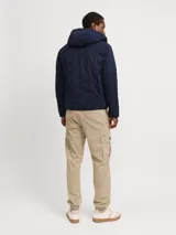 Campera híbrida azul marino con capucha, cierre frontal con cremallera y bolsillos laterales con cierre.
