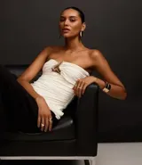 Blusa sin breteles color blanco, confeccionada en microfibra, con escote corazón con cutout, aviamento metalizado y fruncidos.