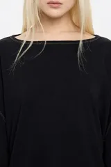 Camiseta negra de manga larga con corte holgado, cuello redondo y pespuntes a contratono.