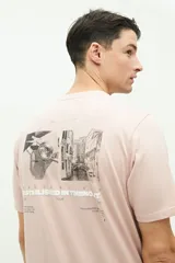 Remera blanca de manga corta con estampado de fotos en la espalda y texto en color ocre.
