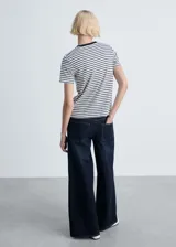 Camiseta blanca con rayas horizontales negras, cuello redondo y ribete en contraste negro.
