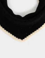 Pañuelo tejido negro con borde a contratono color crema.