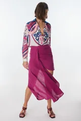 Conjunto de camisa celeste de mangas largas abullonadas y falda turquesa con detalle fruncido y lazo en el lateral.