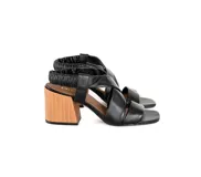 Sandalias negras de cuero con tiras cruzadas y talón elástico fruncido. Taco de madera de 7,5 cm y punta cuadrada.