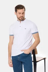 Remera de manga corta color azul grisáceo con cuello mao y tapeta de botones. Los puños de las mangas y el cuello son de color azul marino contrastante. Presenta un pequeño logo bordado en el pecho.