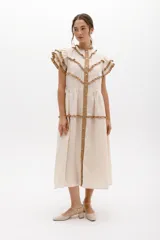 Vestido midi amarillo de lino, con volados en las mangas y detalle de volados y botones a lo largo del frente. Presenta un corte con talle marcado y falda escalonada.