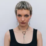 Collar plateado de cadena con dije de candado y cadena colgante.