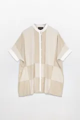Camisola amplia tipo vestido, colorblock en tonos beige y blanco. Cuello mao, abotonada adelante y mangas cortas con puños blancos.