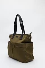 Bolso tote marrón de nylon con doble asa de mano negra y correa bandolera negra regulable y desmontable. Tiene dos bolsillos frontales con cierre metálico dorado.