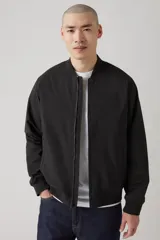 Campera bomber negra con cierre frontal, cuello redondo y bolsillos laterales.