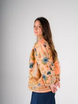 Chaqueta color salmón con bordado floral estilo Suzani en tonos azules, marrones y verdes.