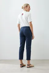 Pantalón chino azul marino con corte recto, bolsillos laterales y traseros, y dobladillo en el tobillo.