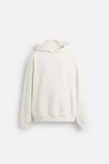 Sudadera con capucha color crudo, de corte holgado, con bolsillo tipo canguro y terminaciones en rib.