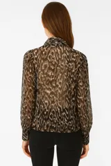 Blusa de poliéster estampada en tonos blanco y negro, con cuello a la base y lazo al cuello.