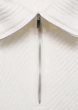 Sweater de punto grueso color blanco con rayas horizontales negras, cuello alto con cremallera y mangas largas.
