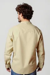 Camisa blanca de cuello mao y mangas 3/4 con botón para sujetar.